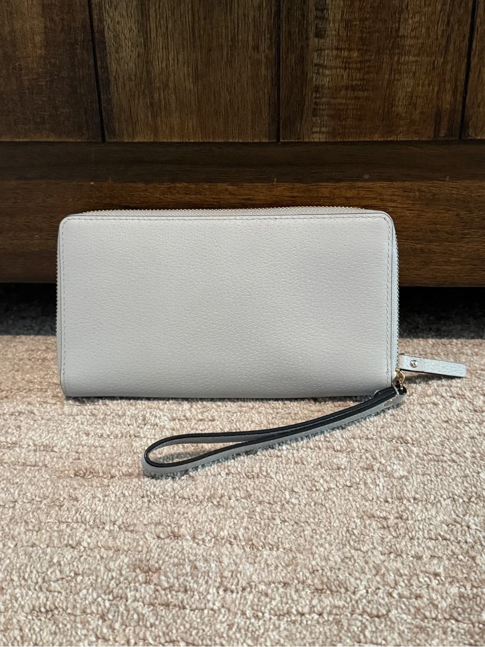 Kate Spade light gray zip-around wristlet wallet with gold logo